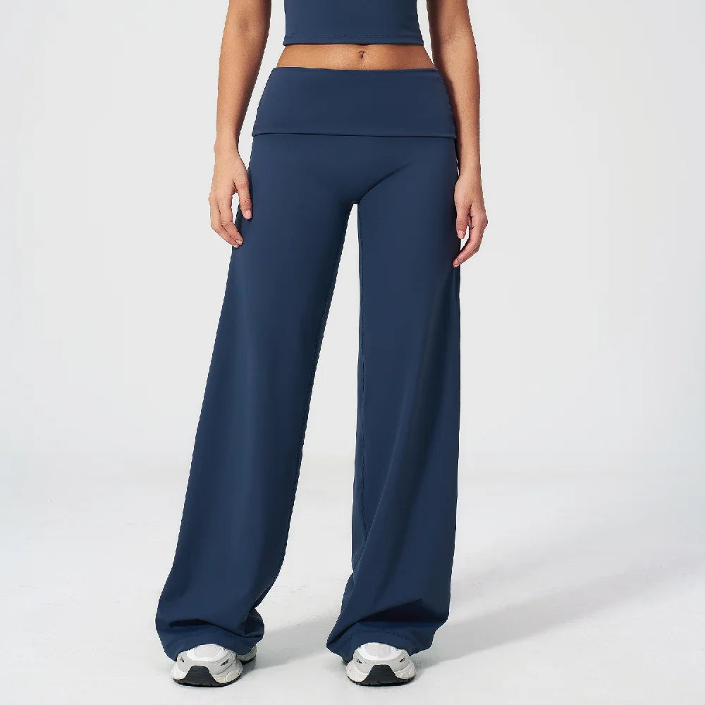 A model wearing navy blue flared high-waist yoga pants and a matching crop top.