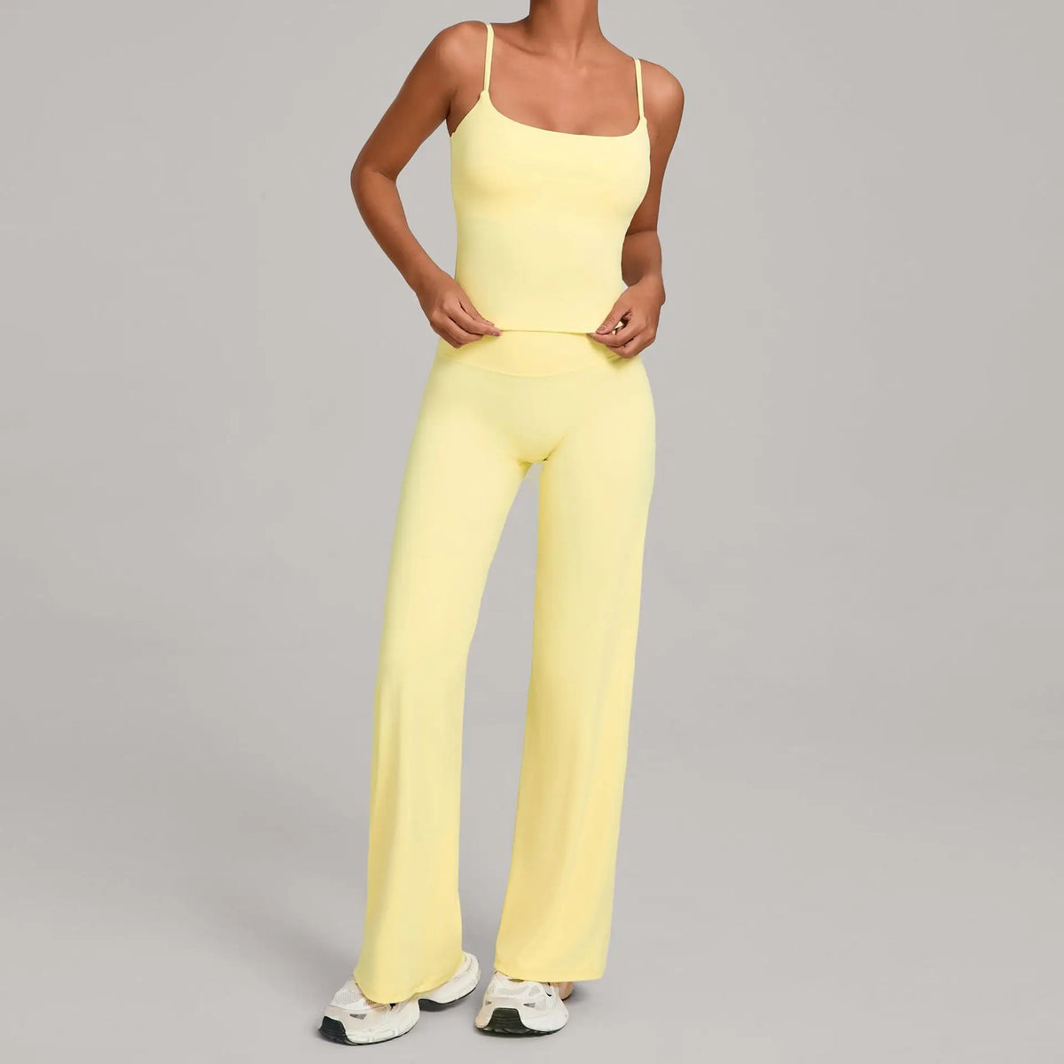 A woman wearing a yellow high-waist yoga and fitness tracksuit set.
