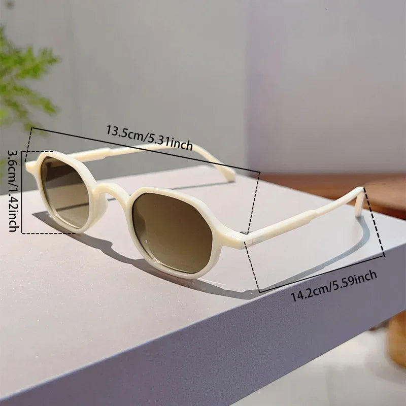 A pair of vintage oval sunglasses with light beige frames and tinted lenses displayed on a white surface.
