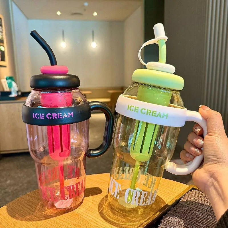 A hand holds a large capacity plastic sports water bottle with a straw, filled with ice cream.