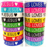 A collection of silicone religious cuff bracelets in various colors, featuring the word Jesus and hearts.