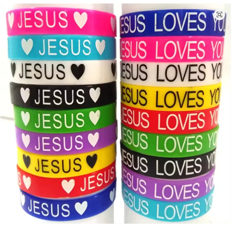 A collection of silicone religious cuff bracelets in various colors, featuring the word Jesus and hearts.