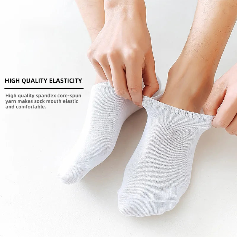 A pair of white men's invisible silicone no-show socks being held by a person's hands.