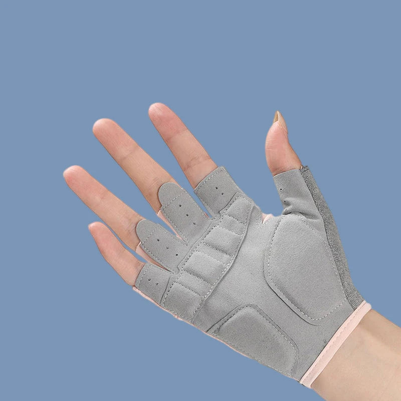 Gray half finger sports gloves worn on a hand against a blue-gray background.