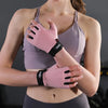Eine Frau trägt ein hellviolettes Sport-BH und rosa rutschfeste Handschuhe für das Fitnesstraining.