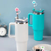 A white silicone butterfly straw cover is shown on a tumbler, with a teal mug featuring a matching straw and flower topper.