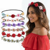 A woman models a floral rose wreath crown headpiece with various colored flowers on her hair.