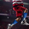 A person wearing a white and red sports uniform is mid-air, showing compression socks on their legs.