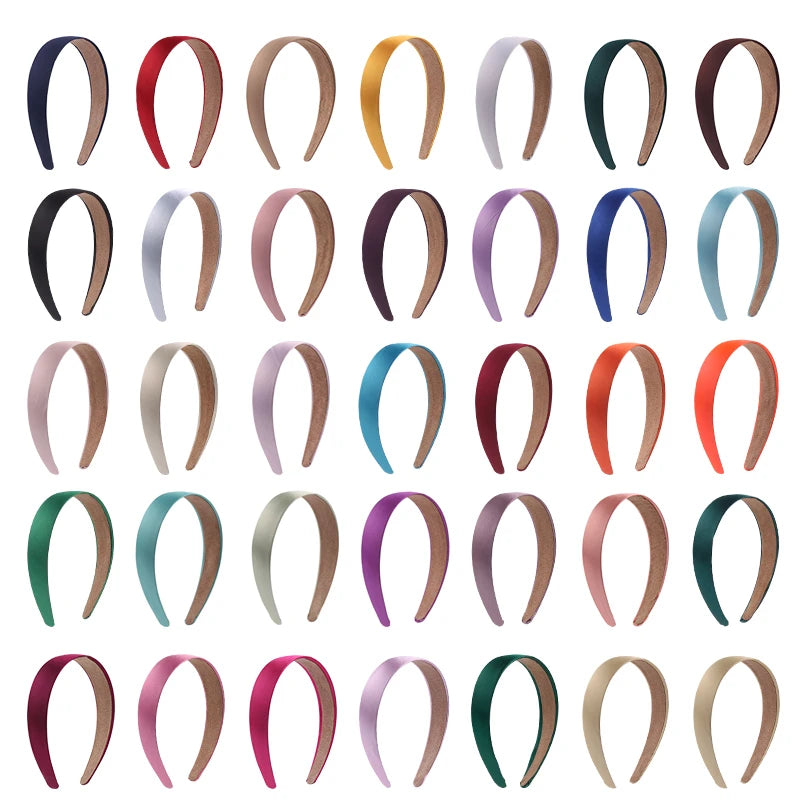 A collection of solid satin hair bands in various colors and finishes.