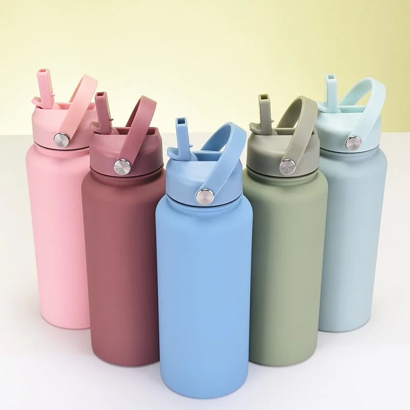 A collection of pink, mauve, and light blue stainless steel vacuum flask water bottles with straws arranged on a white surfac