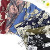 Collection de bandeaux de tête en coton élastique à motifs floraux colorés style bohème, disposés sur une surface blanche.
