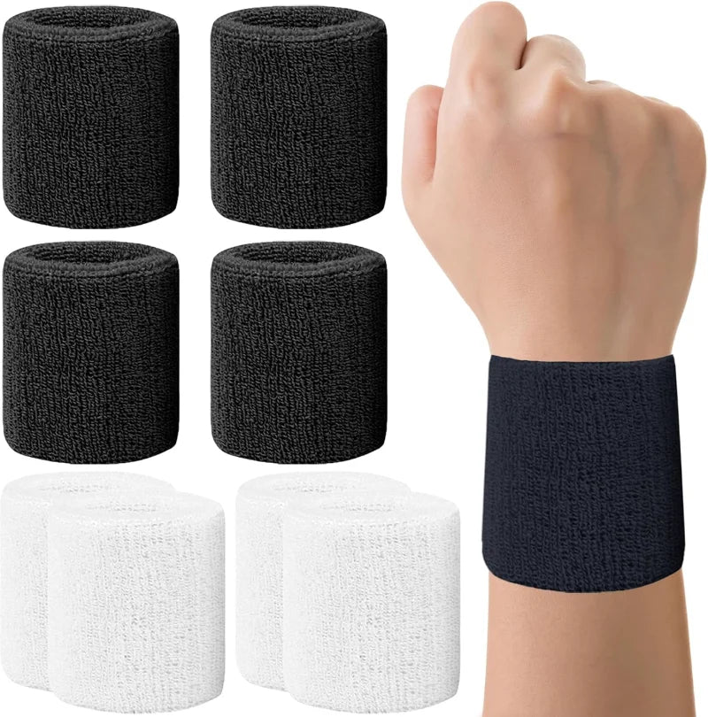 A hand is holding a black and white set of multi-sport breathable wristbands for activewear.