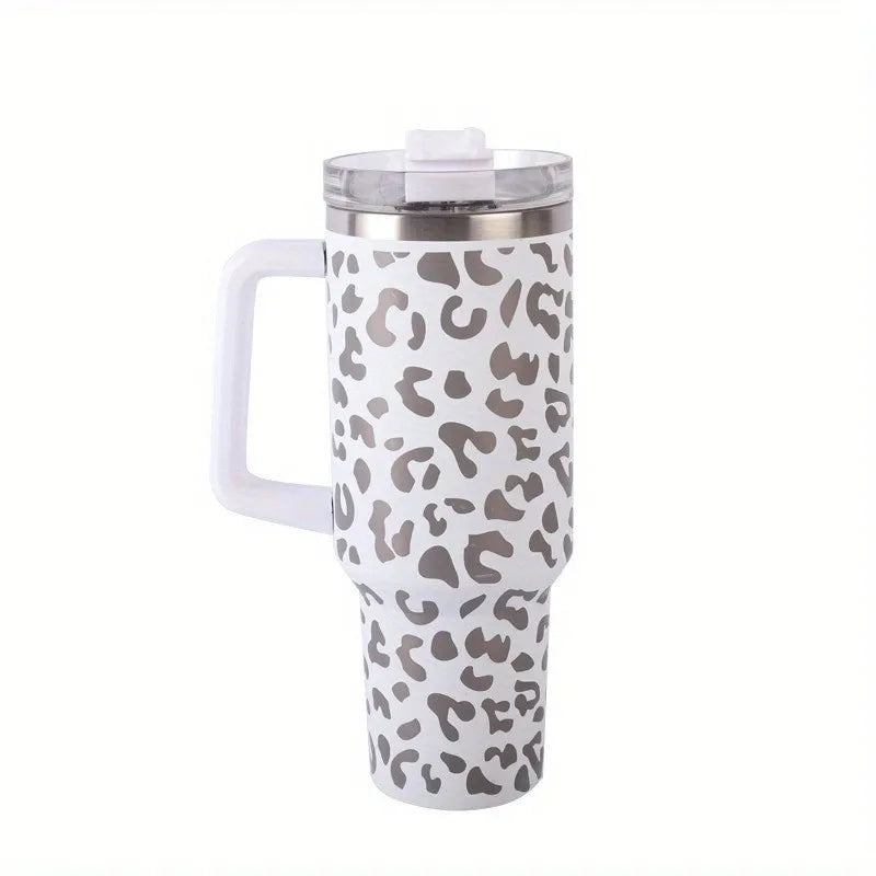 Tasse isotherme en acier inoxydable avec poignée blanche et motif léopard.