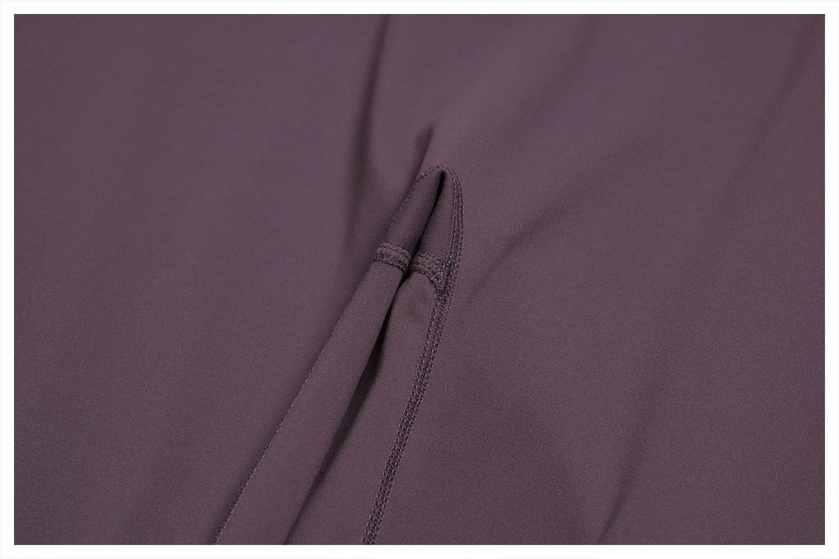 Close-up of a mauve women's high-waist flared yoga pant fabric showing a seam detail.