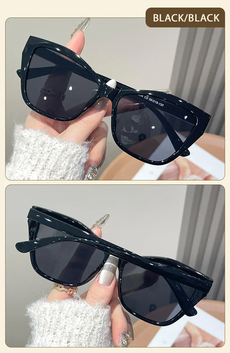 Black square cat eye sunglasses with white knit sleeve shown in a close-up shot.
