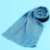 A light blue microfiber cooling towel is rolled up, showing its mesh texture against a white background.