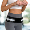 A woman wearing a gray athletic outfit with a black and white supportive hip belt for lower back relief.