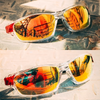 Une paire de lunettes de soleil polarisées teintes en orange posée sur une surface claire.