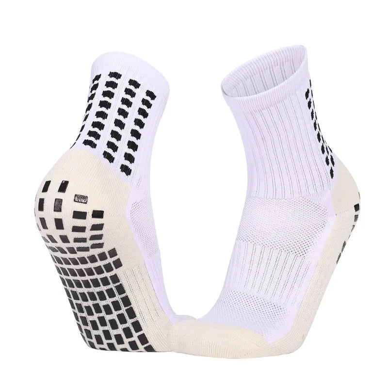A pair of white and beige performance sports grip socks shown from the side.