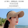 A woman wearing a beige breathable anti-UV adjustable sun hat outdoors near the sea.