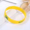 Yellow silicone wristband with the Brazilian flag design resting on a white surface.
