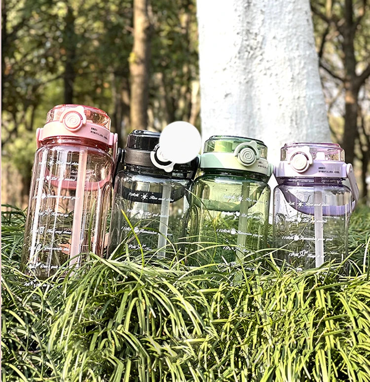 A collection of clear water bottles with various colored lids and a white light, resting on green foliage.