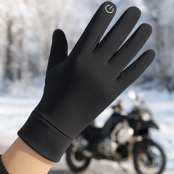A close-up of a black winter cycling glove with a touch screen feature being worn by a hand in an outdoor setting.