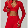 Eine Frau trägt ein rotes, nahtloses Sport-Yoga-Set mit langärmeligem Oberteil und passenden Leggings.