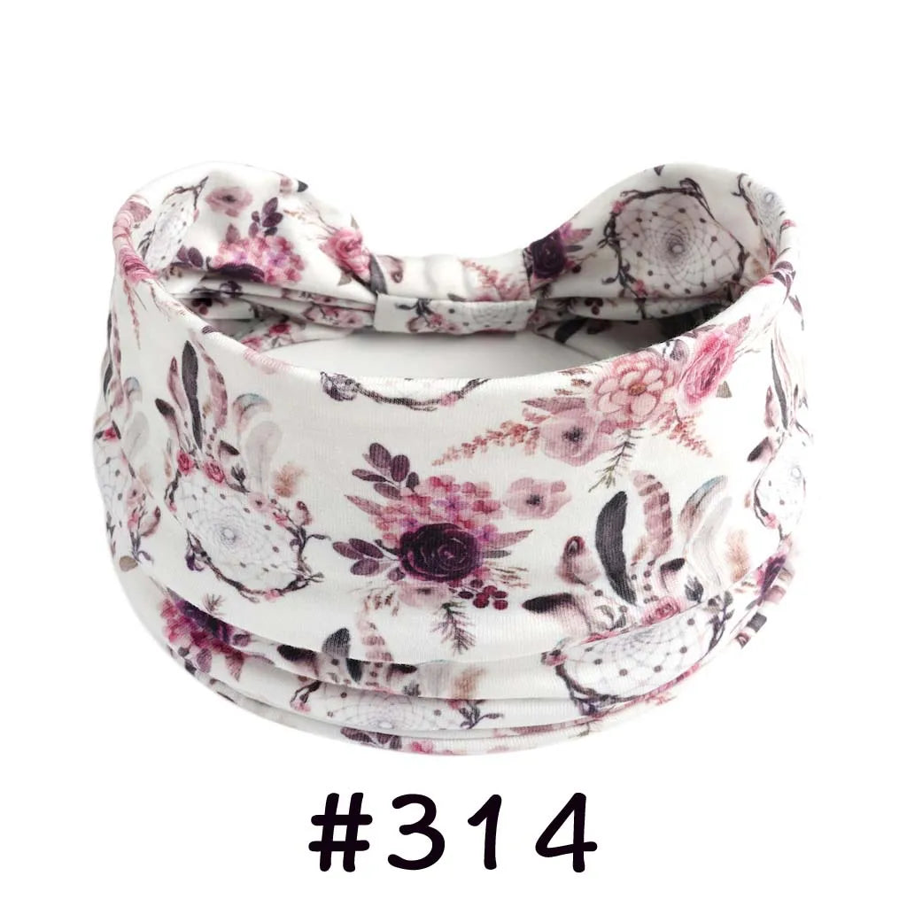 A floral patterned fabric headband tied in a bow, suitable for yoga or workout.