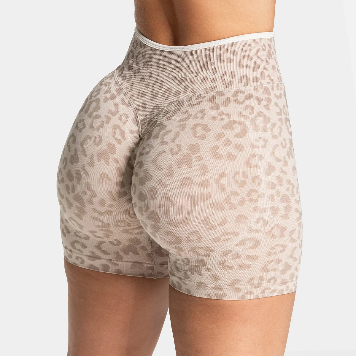 Light beige leopard print seamless yoga shorts worn by a model.