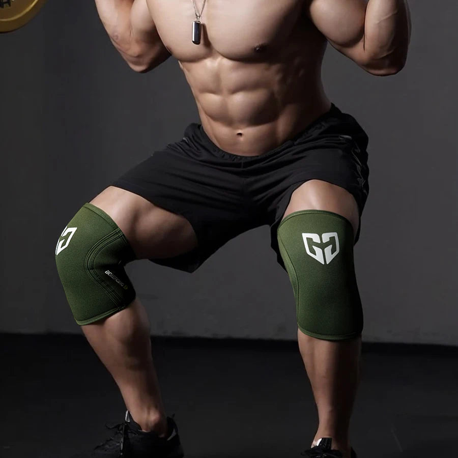A muscular man wearing green compression knee sleeves while posing for a gym photo.