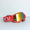 A pair of red sport-grade skiing goggles with orange tinted lenses resting on a white surface.