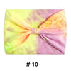 Un bandeau en coton tie-dye rose et jaune noué en nœud.