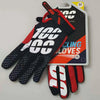 A pair of black and orange sports gloves for outdoor activities displayed next to their packaging.