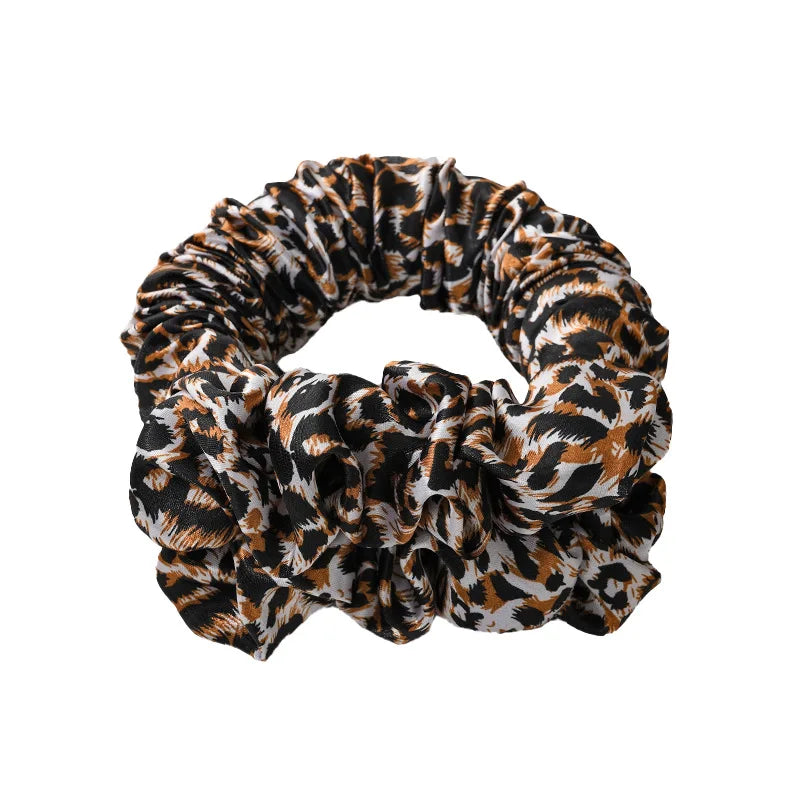 A black and brown leopard print heatless curling rod headband tied in a voluminous knot.