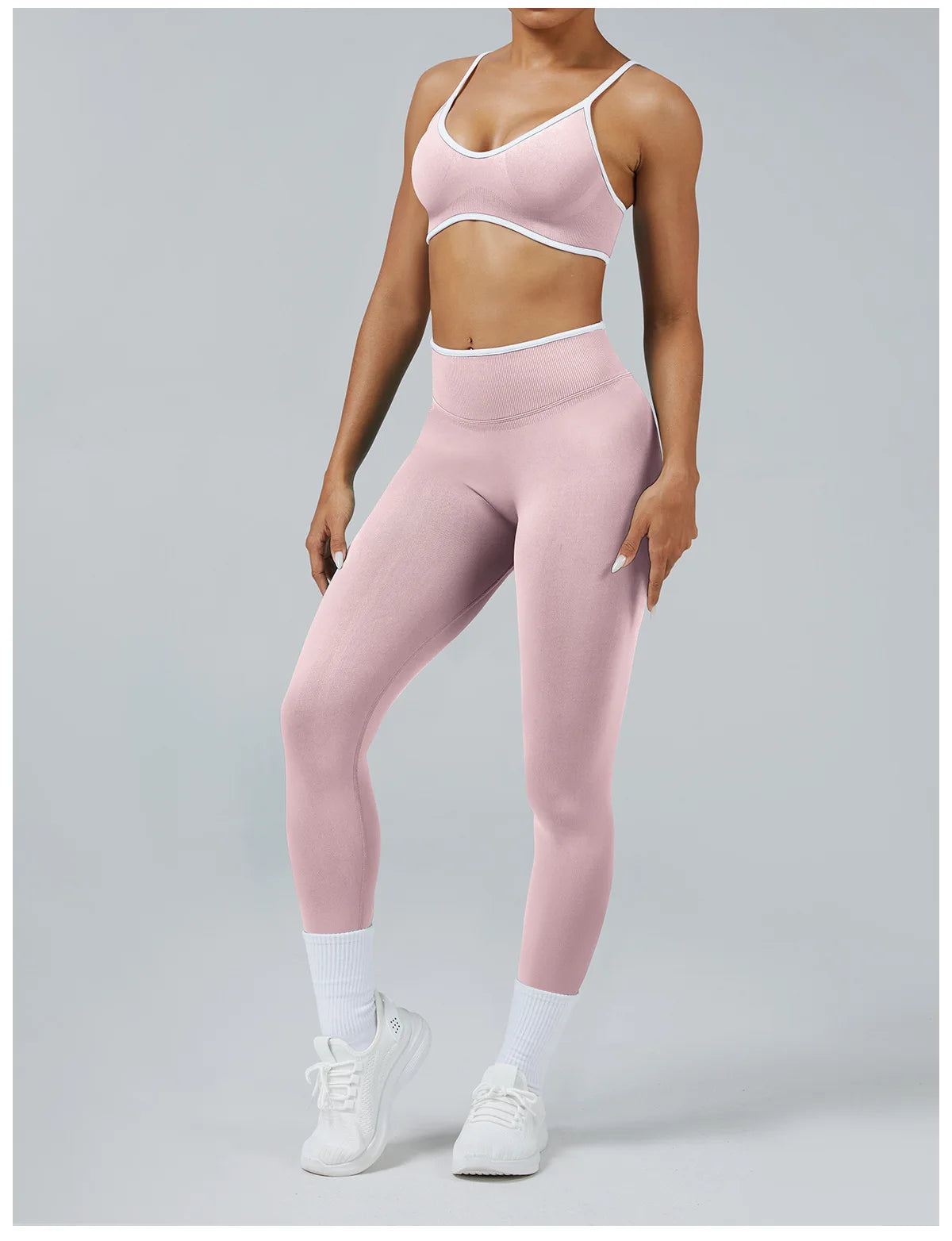 A woman wearing light pink high-waist yoga leggings and a matching sports bra top.
