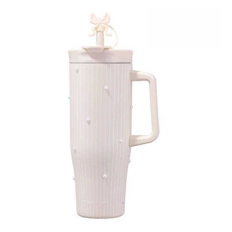 A white insulated thermos mug with a light pink lid and a textured body.
