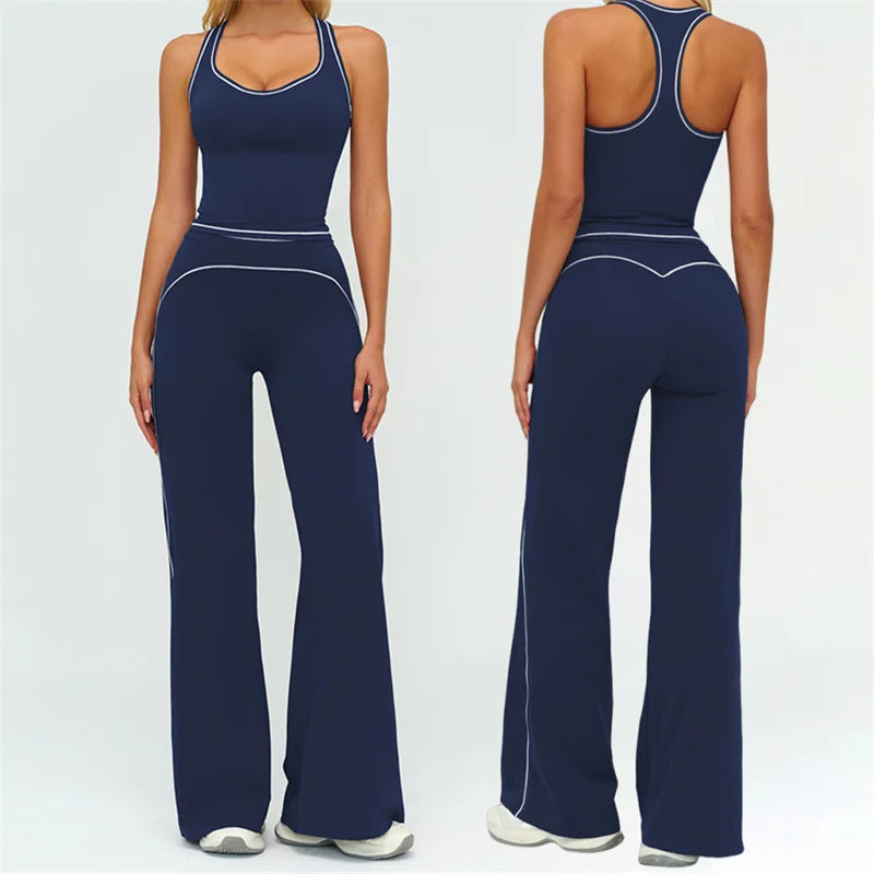 Una mujer modela un conjunto de chándal de yoga azul marino de talle alto con ribetes blancos.
