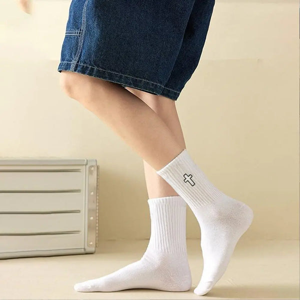 A close-up of white men's high-cut breathable casual crew socks worn on a person's foot.