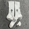 White athletic socks with black cross patterns on the toes and heel.
