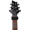 A close-up view of a black electric guitar neck showing the tuning pegs and fretboard.