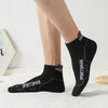 Black men's athletic socks with the Sportsman logo worn on a person's foot.