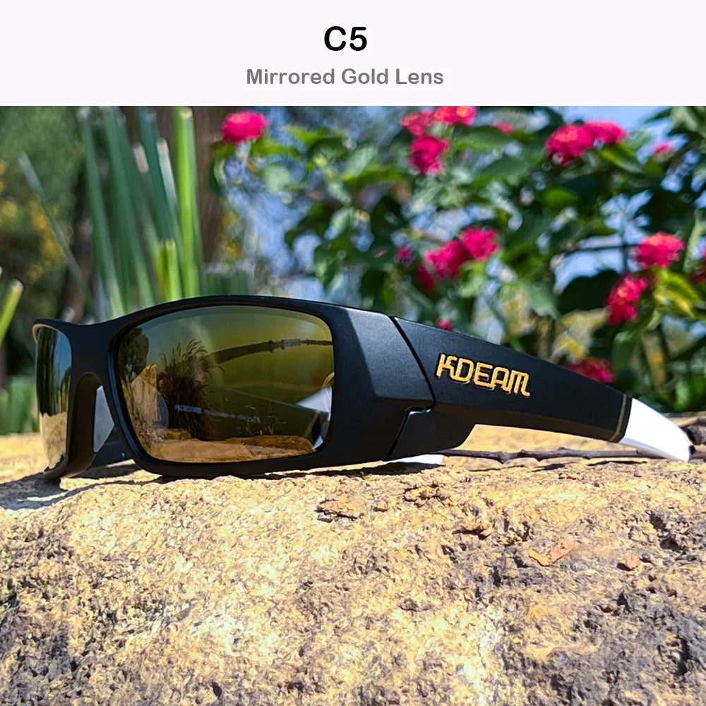 A black KDEAM C5 mirrored gold lens sunglasses resting on a textured rock outdoors.
