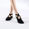 Black breathable silicone yoga and pilates socks worn on a person's foot.
