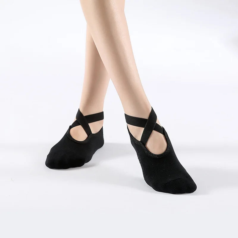 Black breathable silicone yoga and pilates socks worn on a person's foot.