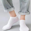 Un par de calcetines náuticos casuales blancos y transpirables puestos en el pie y tobillo de una persona.