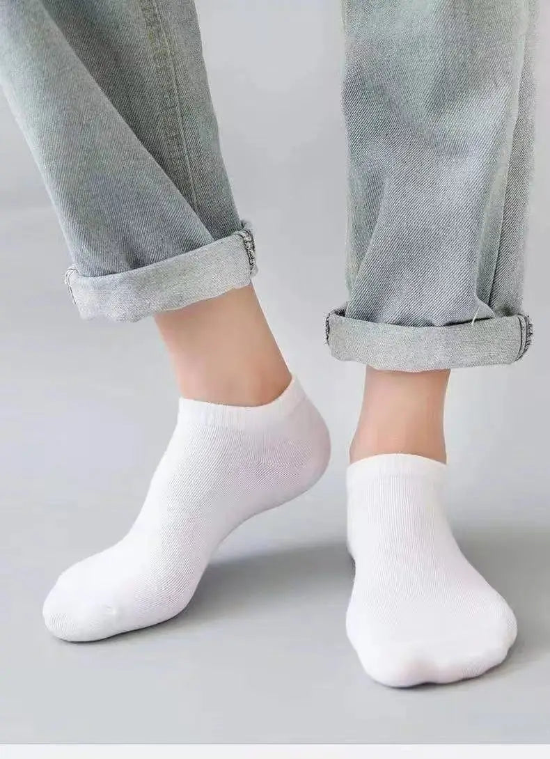 Un par de calcetines náuticos casuales blancos y transpirables puestos en el pie y tobillo de una persona.