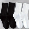Un set de quatre chaussettes en coton mélangé pour hommes, noir et blanc, pour le sport et le quotidien