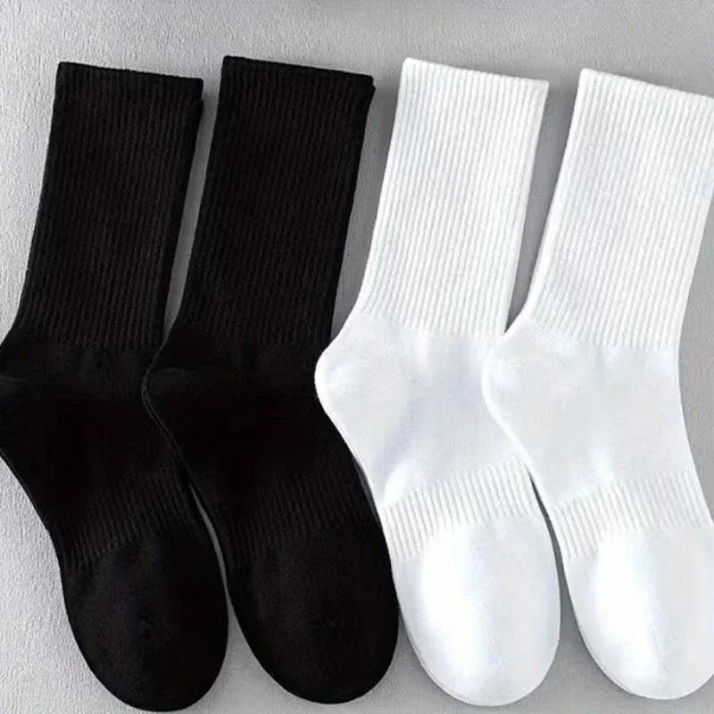 Un set de quatre chaussettes en coton mélangé pour hommes, noir et blanc, pour le sport et le quotidien
