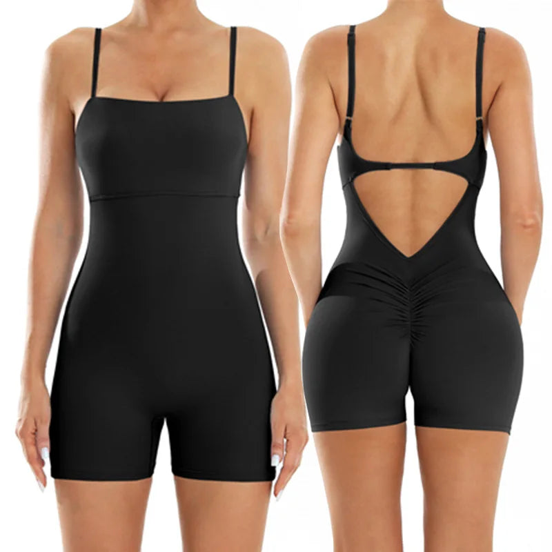 A woman models a black, backless fitness jumpsuit from the rear view.